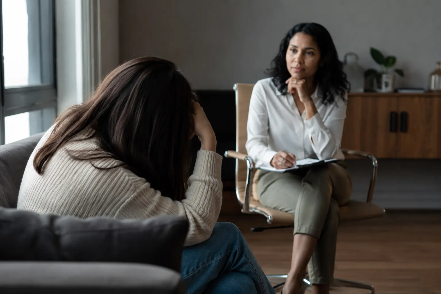 Woman speaking with a psychiatric provider during a mental health consultation in a comfortable counseling office 
